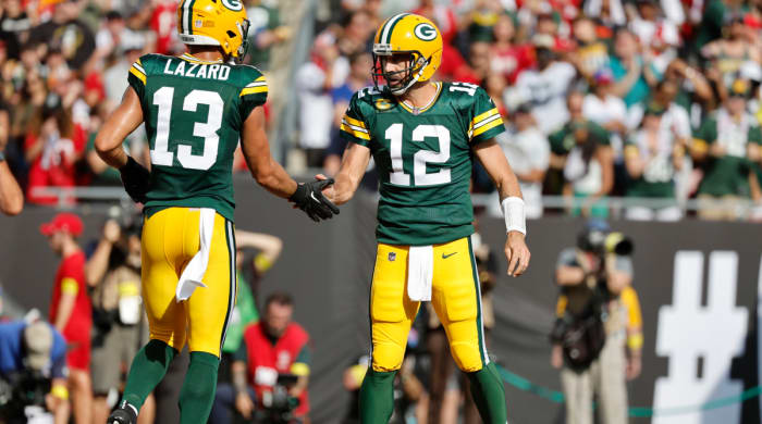 Former Packers WR Allen Lazard high-fives QB Aaron Rodgers.